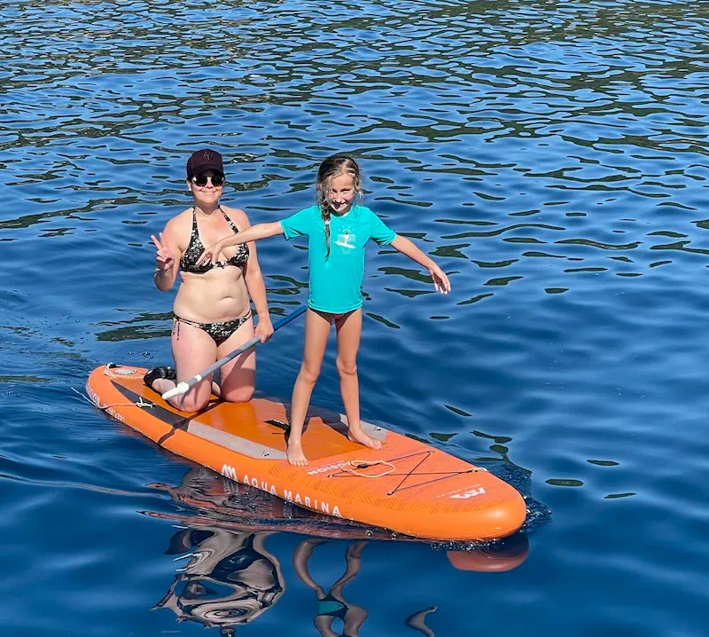 Enfant et sa mère faisant du paddle lors d’une croisière en famille en voilier en Grèce