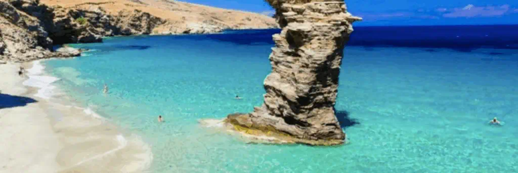 plage à Andros dans les Cyclades en Grèce avec eau turquoise et rocher dans la mer