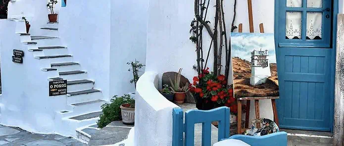 ruelle typique à Andros dans les Cyclades en Grèce avec maison blanche et fleurs