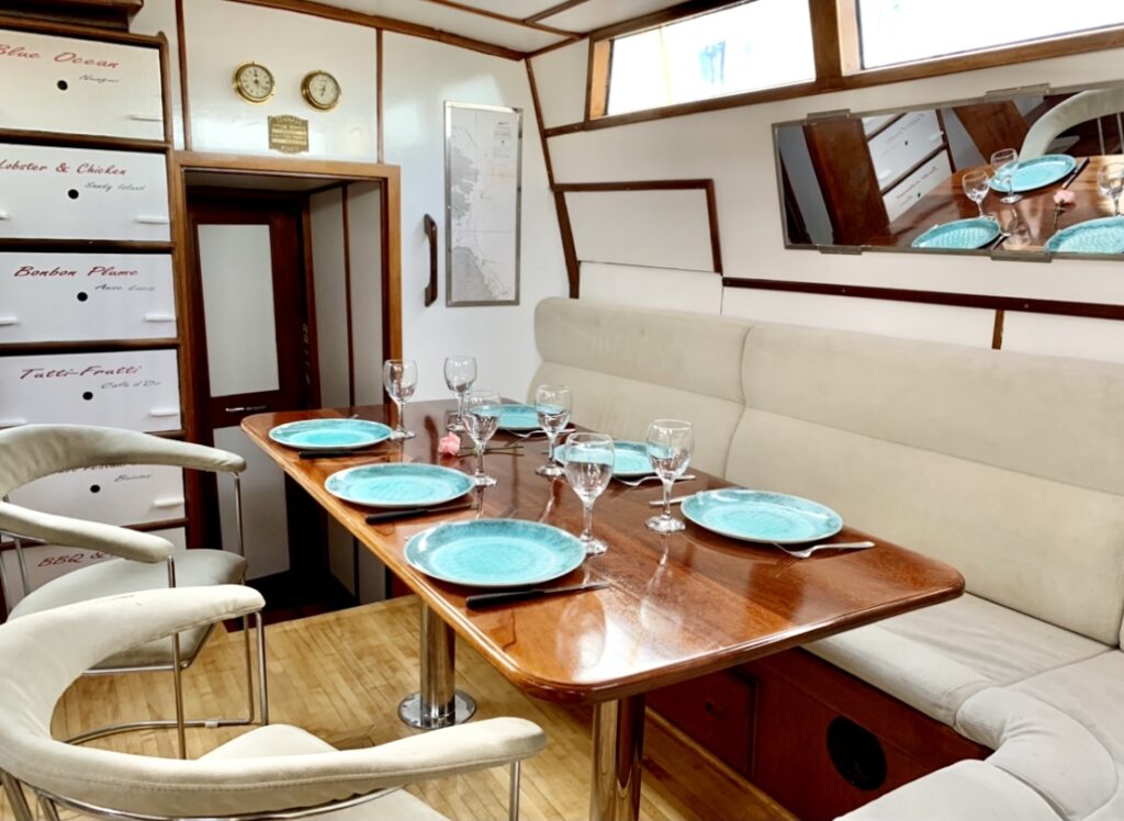 Carré du voilier Najida avec table dressée pour un repas à bord