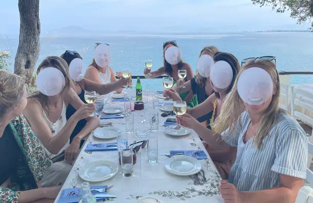 groupe de femmes en croisiere en Grece partageant un repas en bord de mer