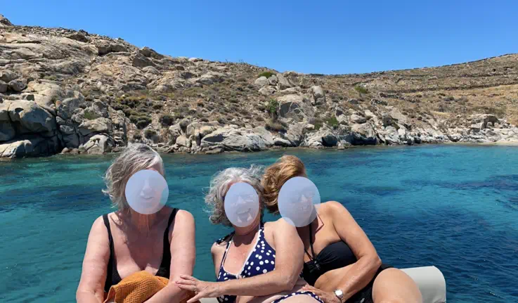 trois femmes se relaxant sur un voilier au mouillage en Grece dans une baie calme
