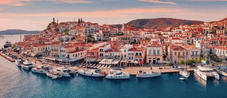 port de Poros en Grece avec voiliers et village en bord de mer