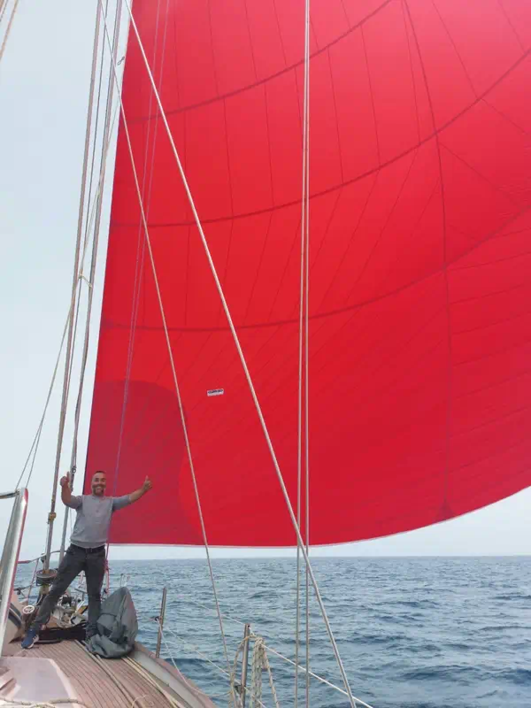Voilier en Grèce naviguant sous spi avec skipper à bord en mer